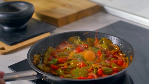 キッチンで働くシェフ、混ぜたカラフルな野菜が鍋で焼く. — ストック動画