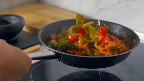 Σεφ που εργάζεται στην κουζίνα, ανάμεικτα πολύχρωμα λαχανικά ψήονται σε ένα τηγάνι. — Αρχείο Βίντεο