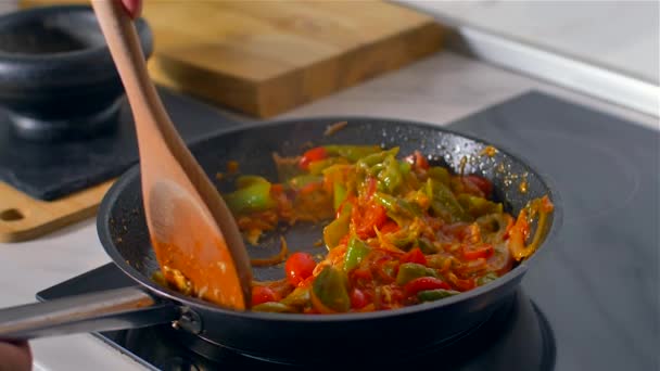 料理人は木製のスプーンで鍋の中で野菜をかき混ぜます。スローモーション — ストック動画
