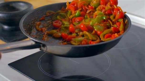 Chef trabajando en la cocina, verduras mixtas de colores se tuestan en una sartén . — Vídeo de stock