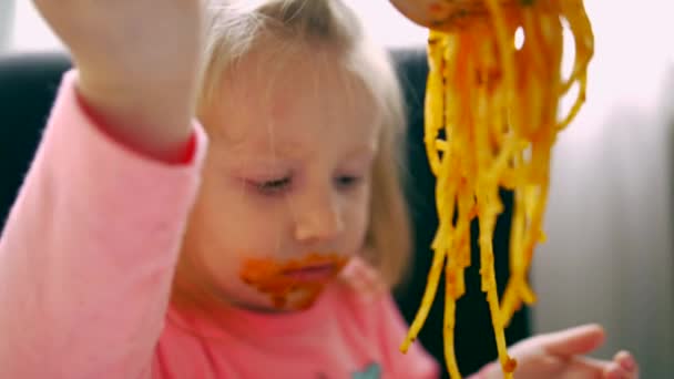 Retrato de cerca de una niña come espaguetis con — Vídeos de Stock