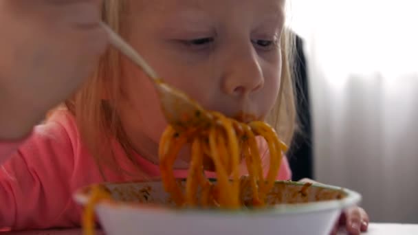 Close up retrato de uma criança menina come espaguete com — Vídeo de Stock