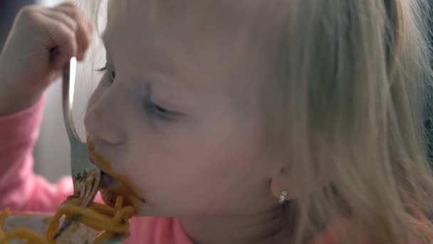 Närbild porträtt av ett barn flicka äter spaghetti med — Stockvideo