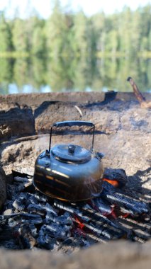 Kamp ateşi kızgın kömürlerin üzerinde kaynar su