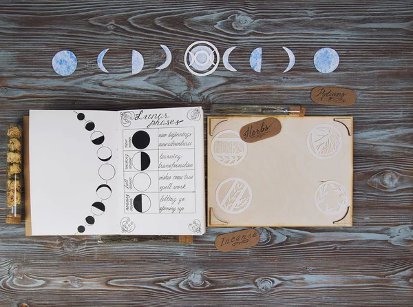 Livro das Sombras com fases lunares no altar de madeira . — Fotografia de Stock