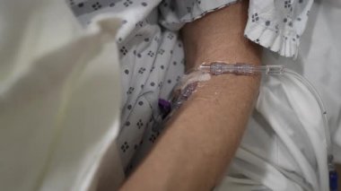 Olgun bir kadın hastanenin acil servisinde tıbbi yardım alıyor. Odak noktası kolunda. Tedavi için damar yolu var..