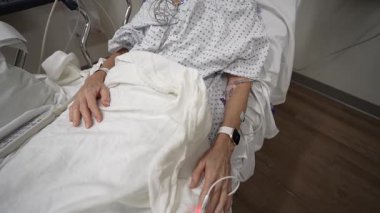 Winchester, VA, ABD - 09 03 2025: Olgun bir kadın acil serviste bir hastane yatağında yatıyor. Dinlenirken onu monitörler ve ekipmanlar sarar..