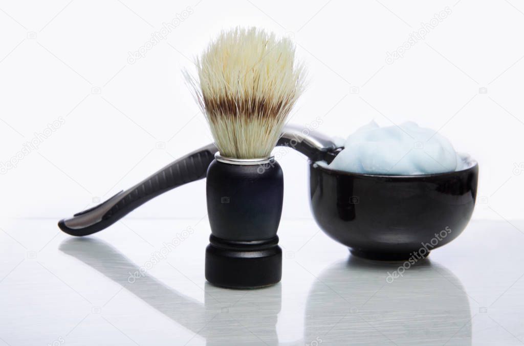 Shaving accessories. Glass table with reflections. White background.