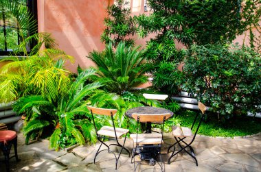 Masa, sandalye ve çiçekler verandada kompozisyonu