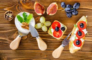 Bruschetta peynir, meyve ve fındık ile ahşap bir masa üzerinde bal ile drizzled.