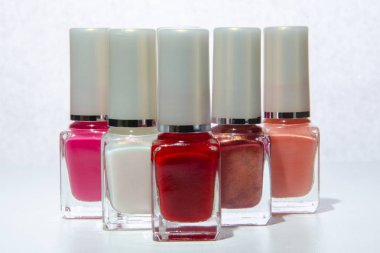 Beyaz bir yüzeyüzerinde oje ile şişeler.