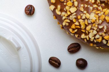 Kahve için kağıt bardak, tek kullanımlık ekolojik kahve malzemeleri. Kağıt tepsilerde çörekler. Tahta masa. Üstte görüntü.