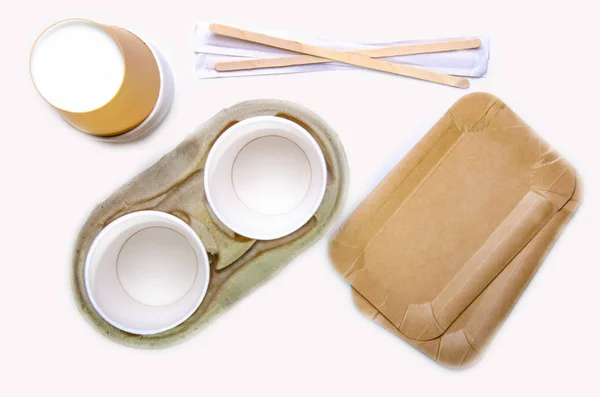 Паперова чашка для кави, одноразове екологічне приладдя для кави. Пончики на паперових лотках. Білий стіл. Вид зверху . — стокове фото