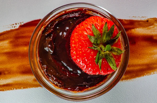 Fresas en la salida con chocolate, una tira de chocolate en una superficie blanca. Vista superior . — Foto de Stock