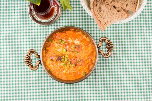 Çay ve domatesli yumurta ve yeşil biber karışımı geleneksel Türk Menmen yemekleri.