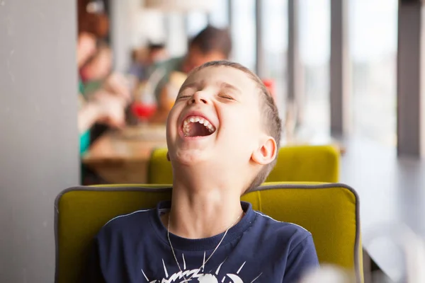 Boy is laughing loudly in cafe — Stock Photo, Image