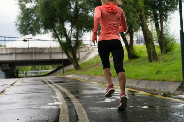 Runner woman running in Park in the rain