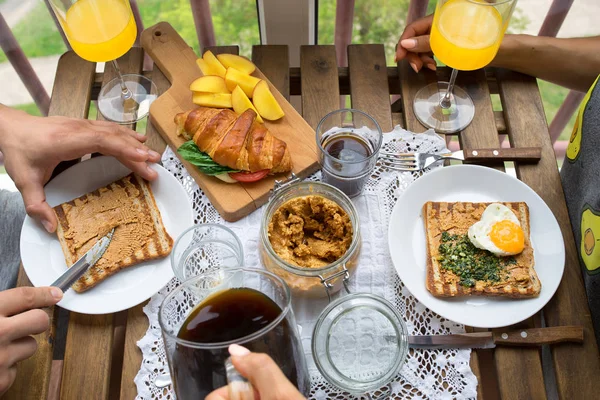 Casal tomando café da manhã na varanda. Café da manhã com torrada, geleia e café — Fotografia de Stock