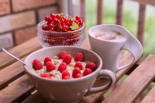 Gesundes Frühstück: Haferflocken mit frischen Beeren in einer Schüssel mit einer Tasse Kaffee — Stockfoto