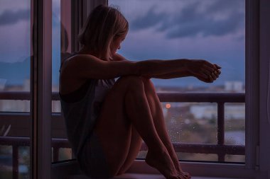 Kadın sabah. Temiz vücut çekici seksi kadın evinde penceresinin üzerinde oturan ve bir fincan kahve ile mükemmel bir rahat sabah sahip gündoğumu bakıyor.