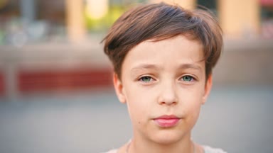 Kameraya bakarak ve gülümseyen Genç beyaz çocuk.