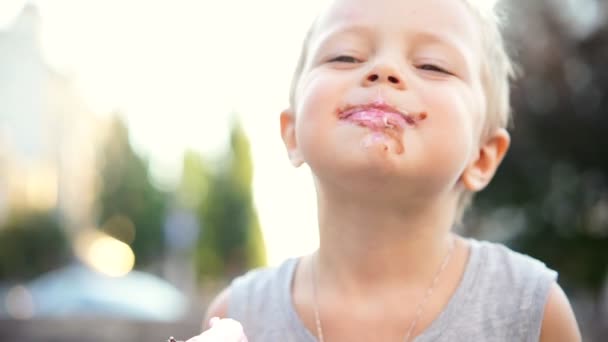 Schattige kleine jongen likken ijs in een kegel gedurende de zomermaanden — Stockvideo