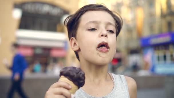 Young boy licking ice cream in a cone during summertime — Stock Video