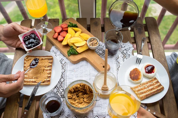 Пара завтракает на балконе. Завтрак с тостами, джемом и кофе — стоковое фото