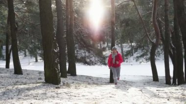 Kadın atlet giyen sıcak giyim çalışan sportif ve eldiven soğuk kış ormanda koşu.