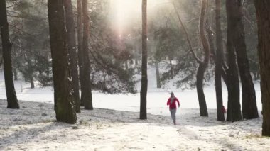 Kadın atlet giyen sıcak giyim çalışan sportif ve eldiven soğuk kış ormanda koşu.