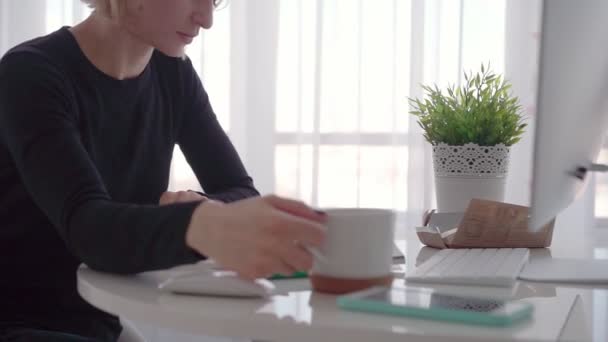 Vista lateral. Jovem mulher de negócios sentada à mesa e tomando notas no caderno. Blogueiro . — Vídeo de Stock