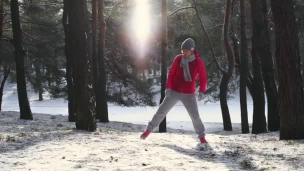 Mulher se aquece antes de correr na floresta fria de inverno — Vídeo de Stock