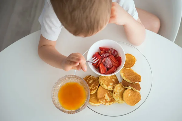 Barnet har frukost på en solig morgon — Stockfoto