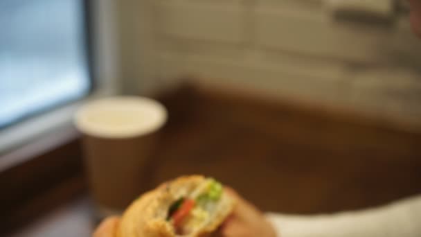 Jovem mulher tomando um café da manhã francês com café e croissant sentado no café — Vídeo de Stock