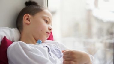 Yakın pencere pervazına üzerinde oturan çocuk sıcaklığının ölçülmesi