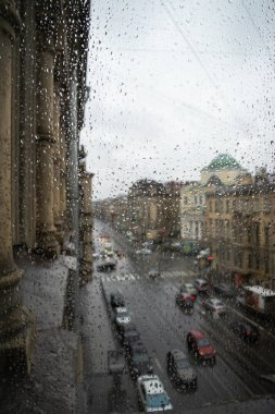 Defocussed trafik yağmur altında kapalı bir araba ön cam ile görüntülendi
