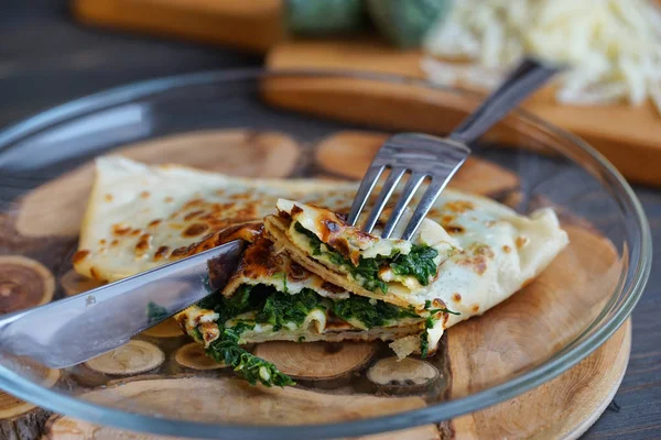 Krep ıspanak ve peynir ahşap yüzeyde dolu. Krep hafta.