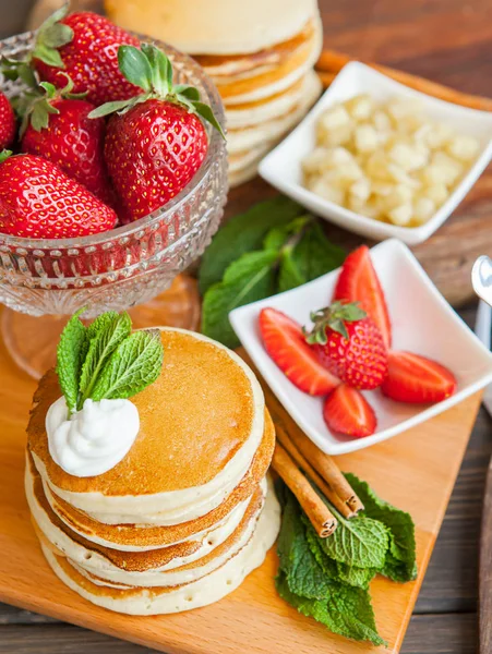 Leckere Pfannkuchen auf Holztisch mit Beeren und Früchten — Stockfoto