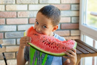 Komik çocuk odaklanmak gözleri kapalı, karpuz yeme.