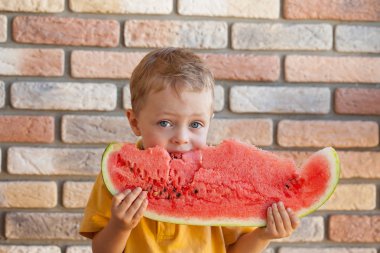 Komik çocuk odaklanmak gözleri kapalı, karpuz yeme.