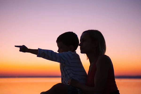 Anne ve küçük oğlu güzel gün batımını izlemek. — Stok fotoğraf