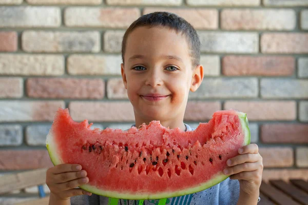 Komik çocuk odaklanmak gözleri kapalı, karpuz yeme.