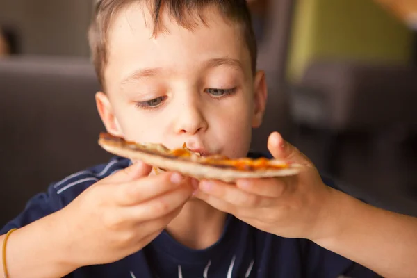 Ребёнок веселится, поедая пиццу — стоковое фото