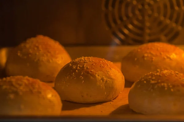 Lekkere zelfgemaakte broodjes met sesam in de oven — Stockfoto