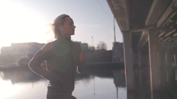 Dopasuj kobieta do biegania w mieście w piękny wschód słońca — Wideo stockowe