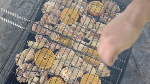 Kip met uien en sinaasappelen verspreid op de grill voor een barbecue — Stockvideo