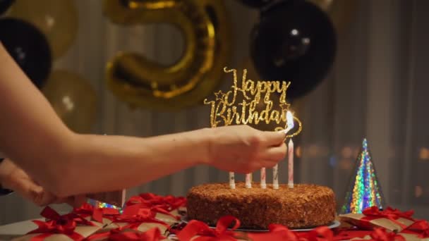 Frau zündet Kerzen auf Geburtstagstorte an — Stockvideo