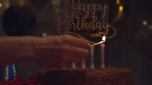 Woman fire candles on birthday cake — Stock Video