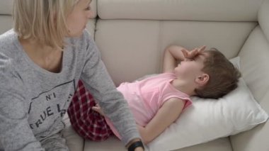 Annesi hasta oğlu sıcaklığını kontrol. Ateş ve yatakta hastalık ile hasta çocuk