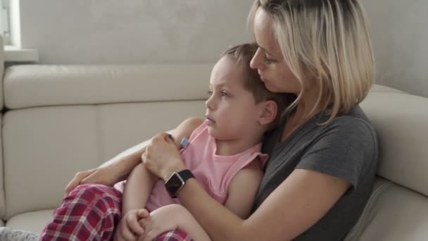 Moeder controle van temperatuur van haar zieke zoon. Ziek kind met koorts en ziekte in bed — Stockvideo